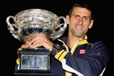 Novak Djokovic of Serbia celebrates with the Norman Brookes Challenge Cup at Melbourne Park.