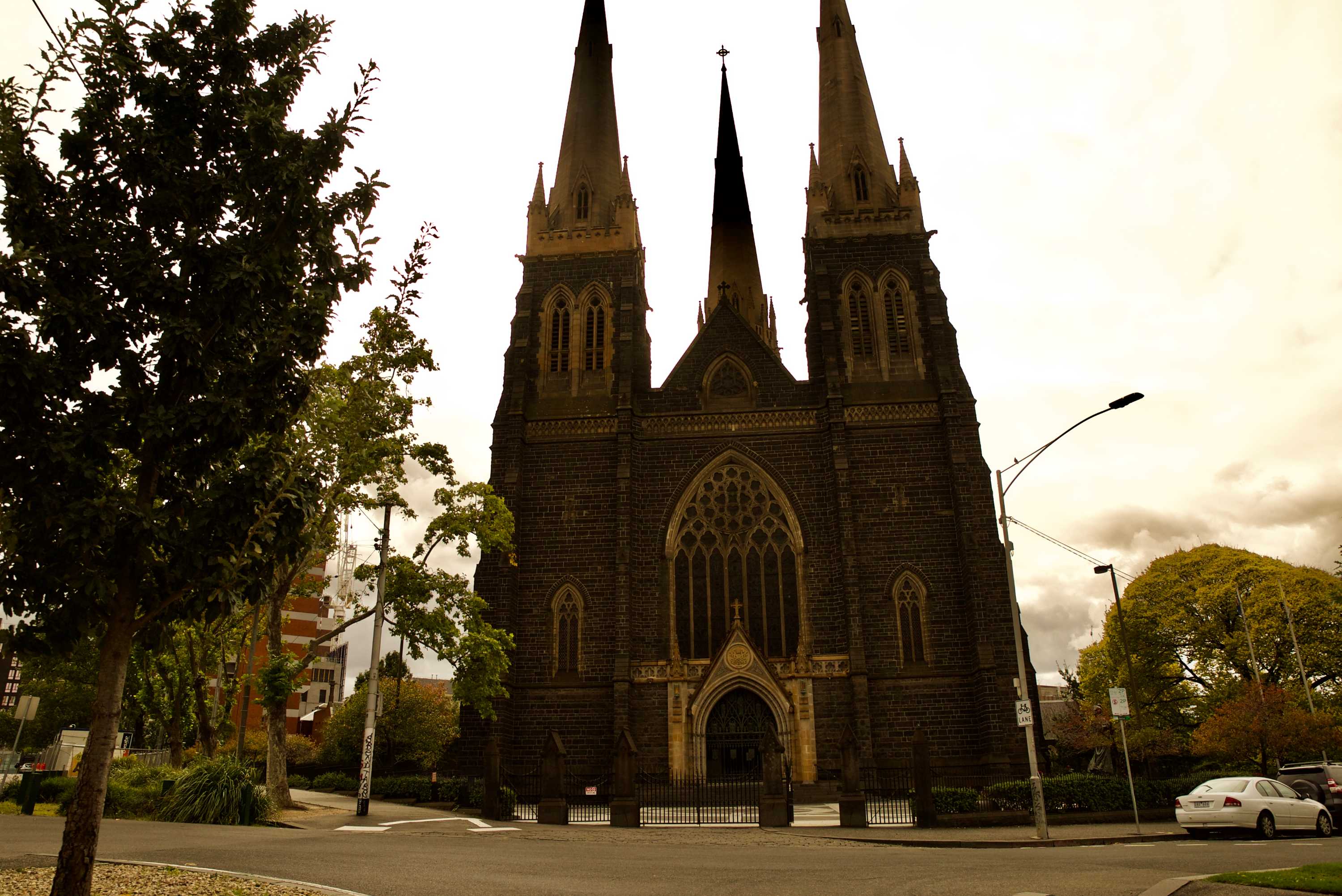 St Patrick's Cathedral in Melbourne, which has towering spires, on a cloudy day.
