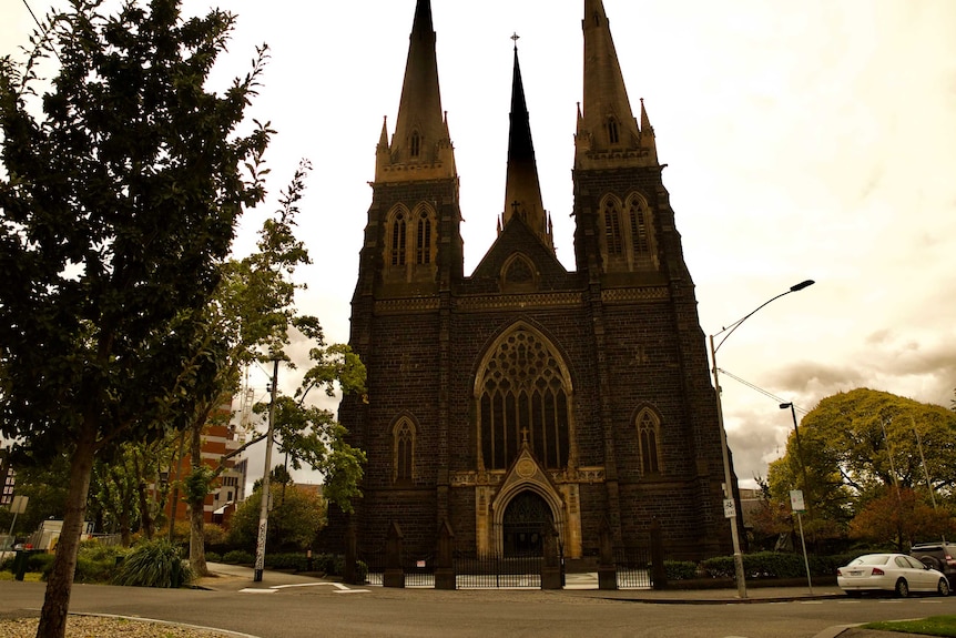 St Patrick's Cathedral in Melbourne, which has towering spires, on a cloudy day.