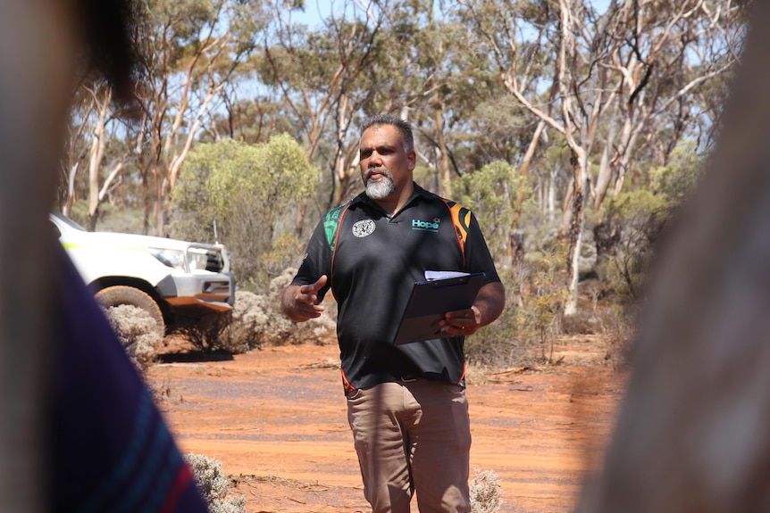 indigenous man standing in bushland