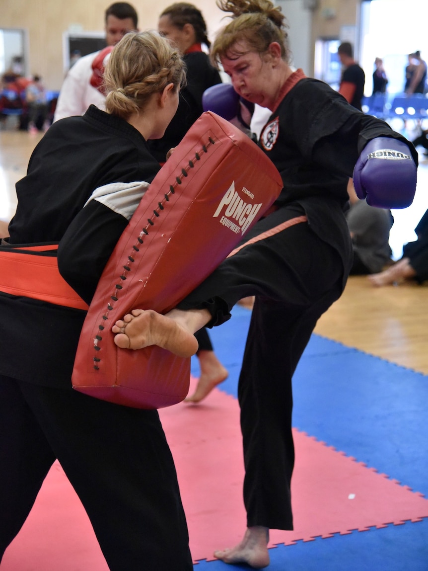 Megan Pitts kicks a training pad held by her partner at a Zen Do Kai gym in Oxley, Brisbane.