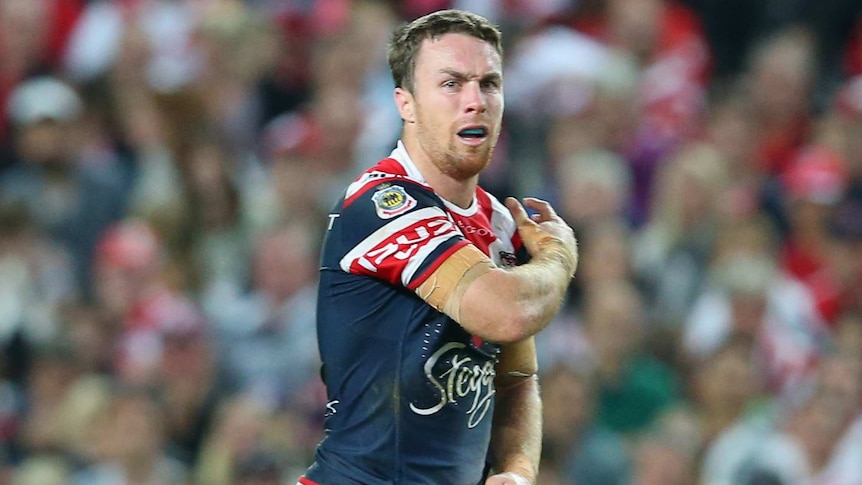 The Roosters' James Maloney holds his shoulder after a tackle against St George Illawarra