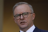 Anthony Albanese mid-sentence while gesturing with his hands, the background is out of focus