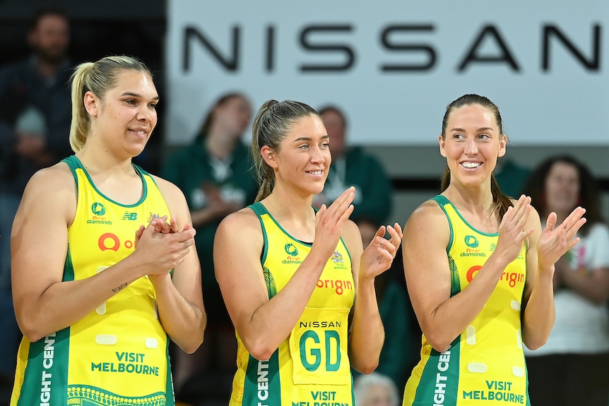 Donnell Wallam, Matilda Garrett and Cara Koenen stand side by side, clapping