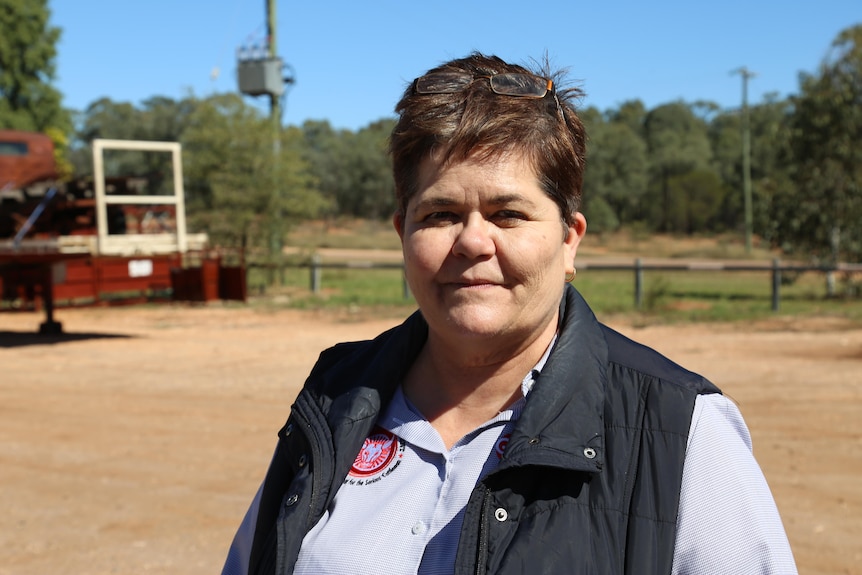 A middle aged woman with brown hair looks at the camera unimpressed 