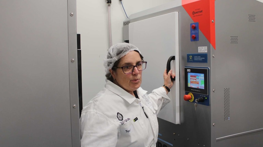 Terril Marais standing between two radiation machines.