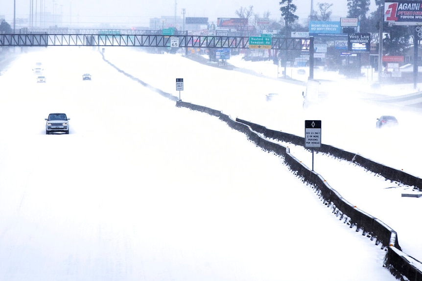 Sparse traffic on a Texas highway covered in snow.