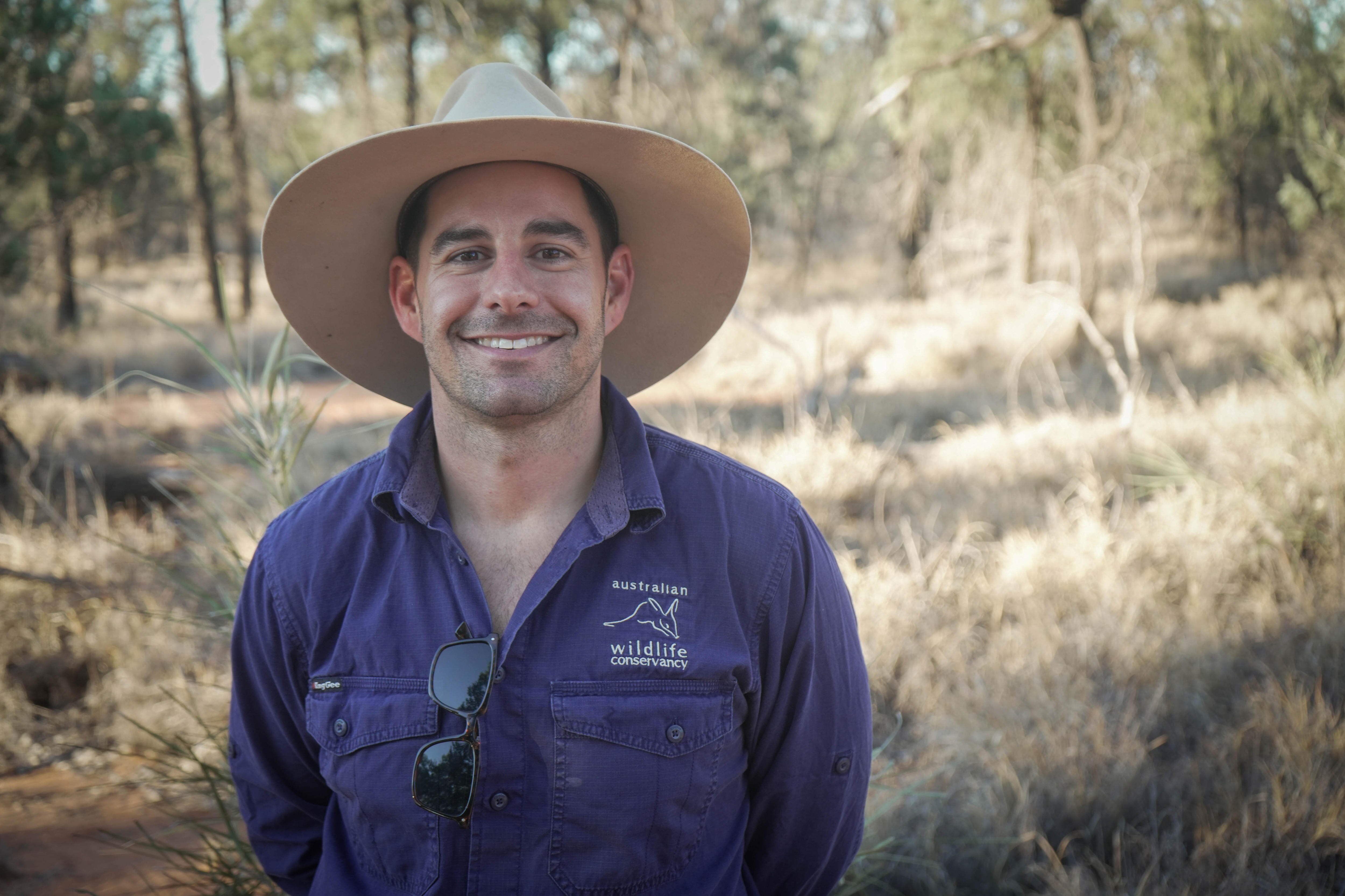a man stands in the bush smiing