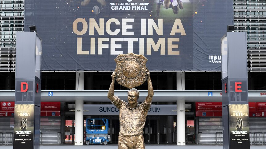 Wally Lewis statue in front of a banner at Lang Park saying "once in a lifetime"