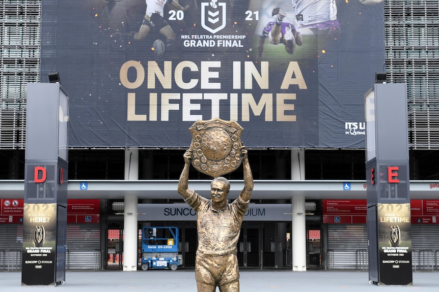 Wally Lewis statue in front of a banner at Lang Park saying "once in a lifetime"