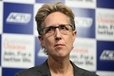 Sally McManus standing in front of an ACTU banner.