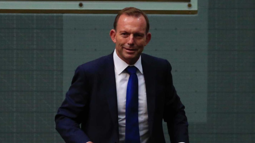 Tony Abbott walks into Parliament holding two glasses of water