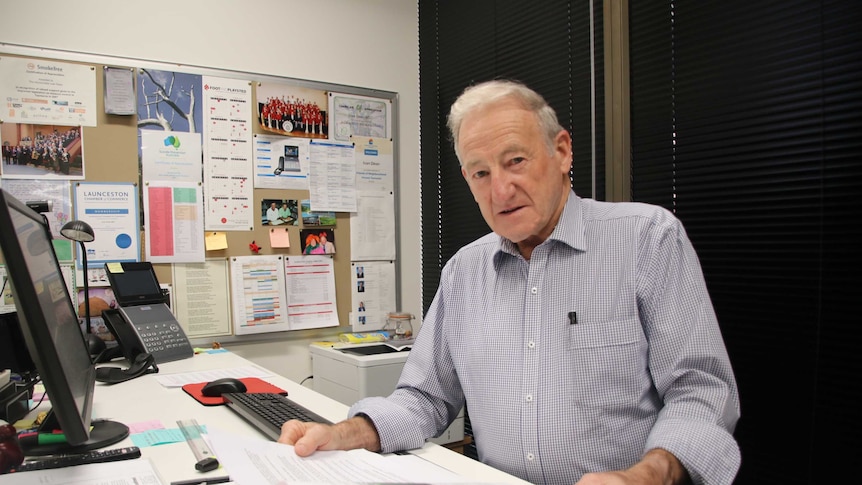 Ivan Dean standing at his desk looking at paperwork