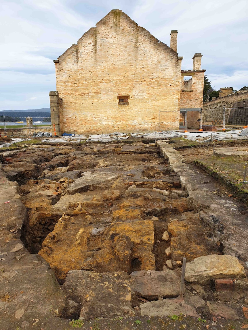 A very old brick building and a dug up site 