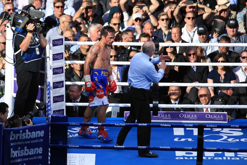 A bloodied Pacquiao stands in the corner of the ring.