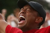 Tiger Woods screams in delight with his eyes closed and arms aloft