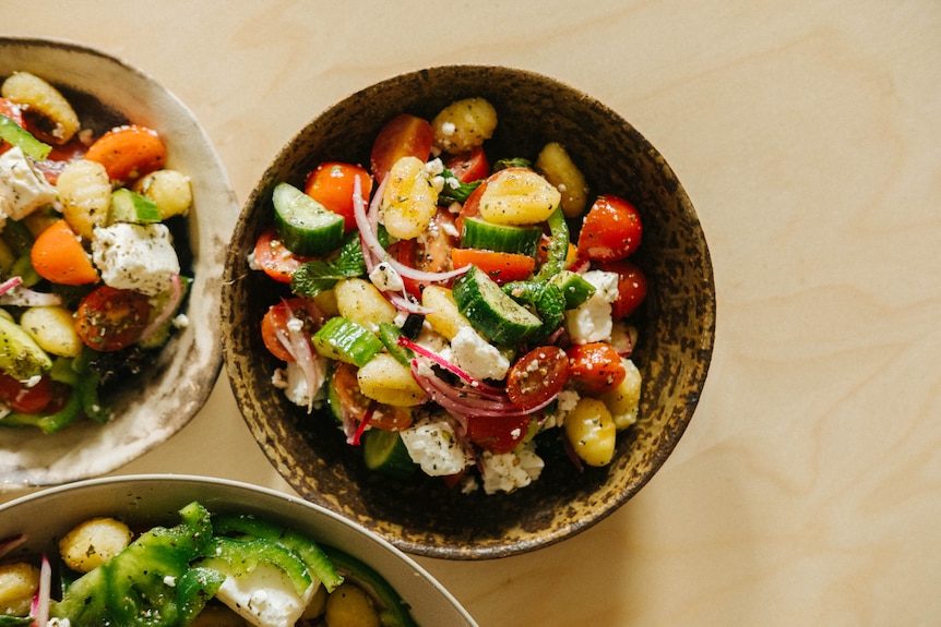 Hetty Lui McKinnon's Greek salad and gnocchi served into bowls for a vegetarian family dinner.
