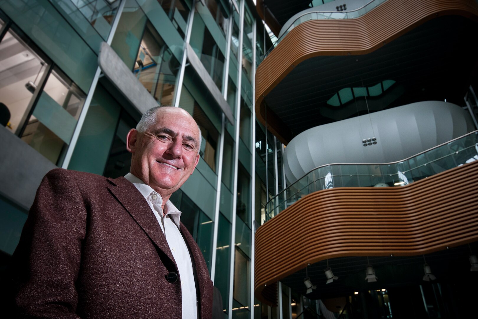 Man stands inside building, posing for camera