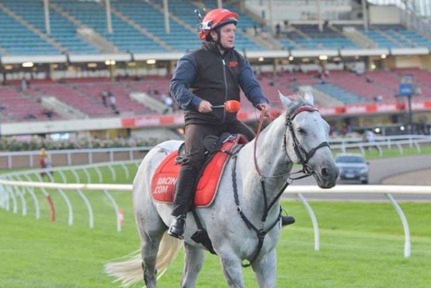 A man on a horse at a racetrack