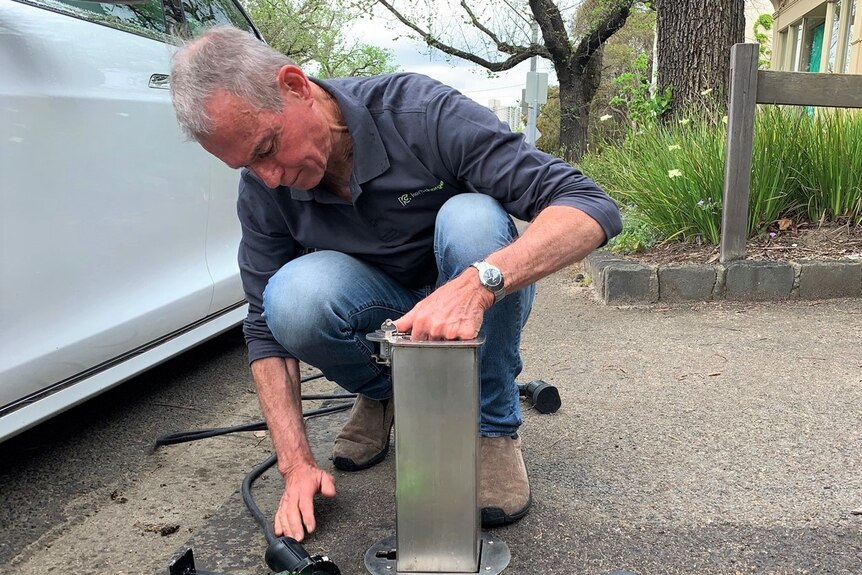 Rod Walker kneels down to install a Kerb Charger.