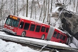 a red bus on a collapsed bridge