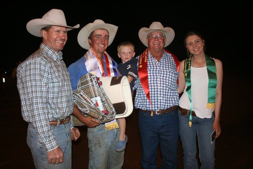 Four winners with their prizes and ribbons, with one holding a toddler.