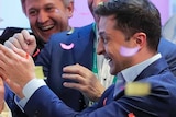Volodymyr Zelenskiy embraces his wife Olana Zelenska, surrounded by supporters who are cheering on him.