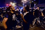Protesters talk with one another while Charlotte police officers monitor the protests in Charlotte.