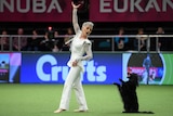 A woman in a white costume poses dramatically next to her dog standing on its hind legs.