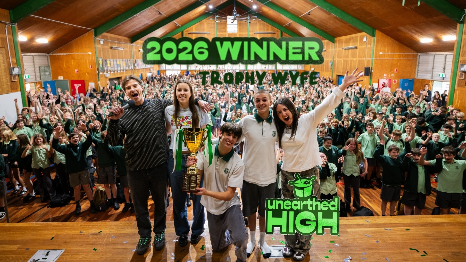 Trophy Wyfe pose with Concetta and Luka, and the Unearthed High trophy in their school hall