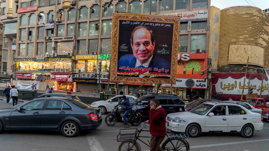 The photo of Egypt President Sisi is seen in a huge gold frame in a busy street, signed by  local supporters.