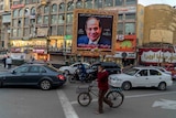The photo of Egypt President Sisi is seen in a huge gold frame in a busy street.