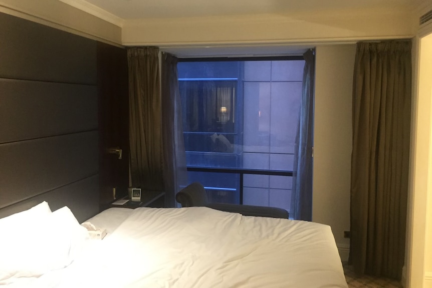 A hotel room with a bed and a window.