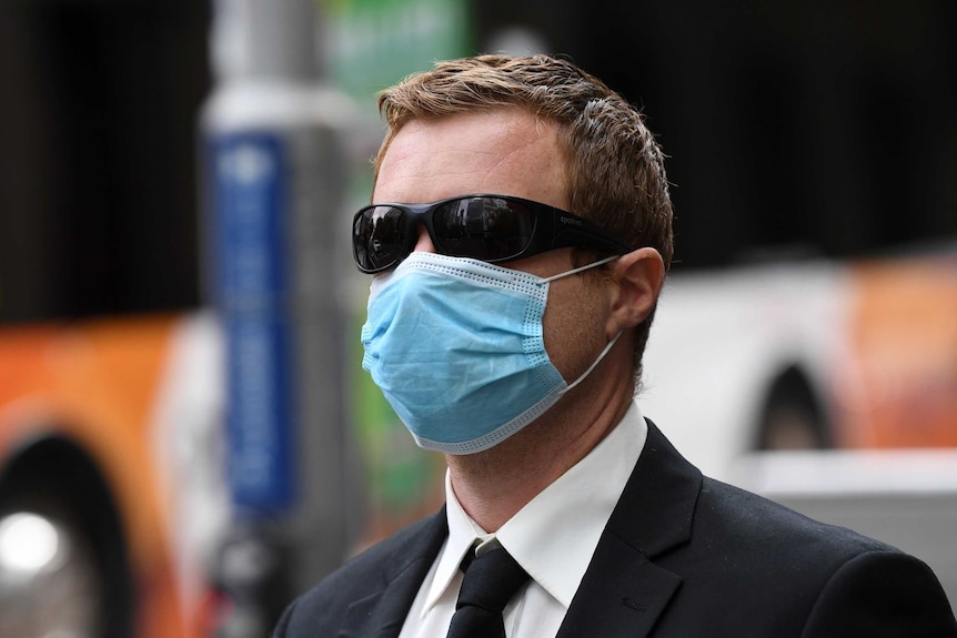 Graeme John Walter departs the County Court of Victoria wearing a surgical face mask and sunglasses.