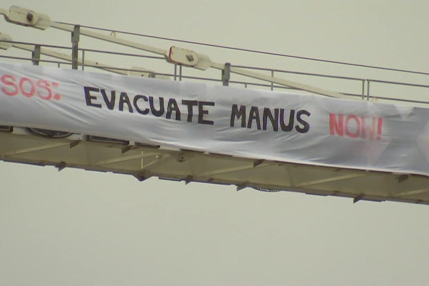 Protesters at the Melbourne Cup unfurl a banner on a crane saying 'Evacuate Manus Now.
