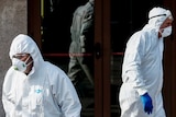 Health officials in hazmat suits disinfect an Italian building