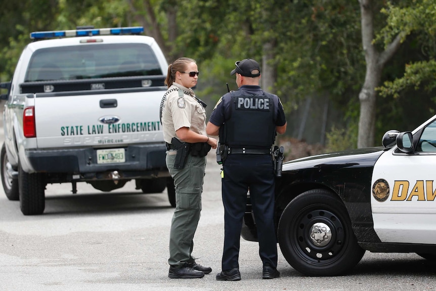 Law enforcement officers gather at the entrance of Silver Lakes Rotary Nature Park.