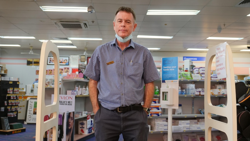 a man stands at the entrance to a pharmacy 