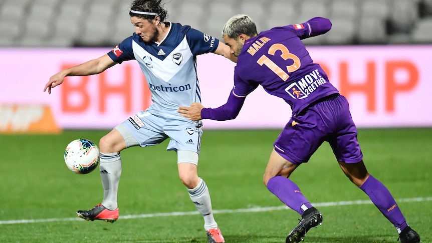 Marco Rojas controls the ball wearing a silver shirt as Osama Malik grabs at him with his left hand