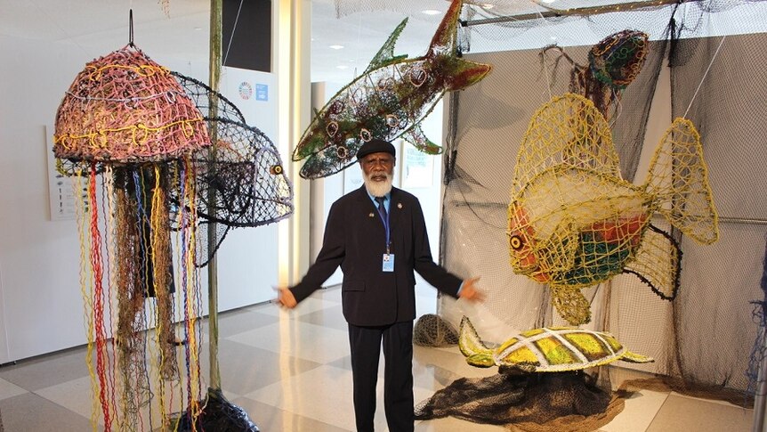 Pormpuraaw artist Sid Bruce Shortjoe in New York, surrounded by his artwork.