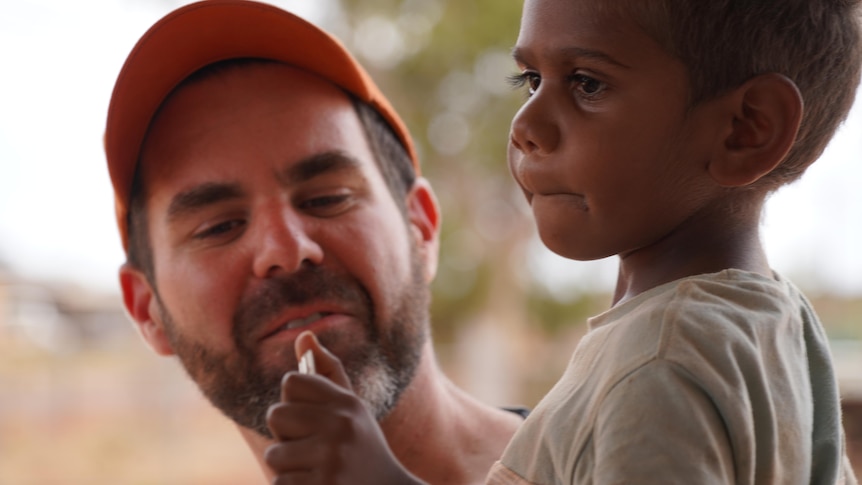 A man with a child holding a key