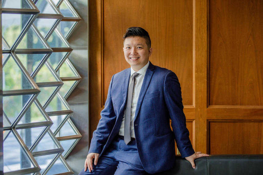 Man in a blue suit smiling at the camera