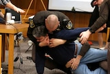 Eaton County Sheriffs restrain Randall Margraves after he lunged at Larry Nassar.