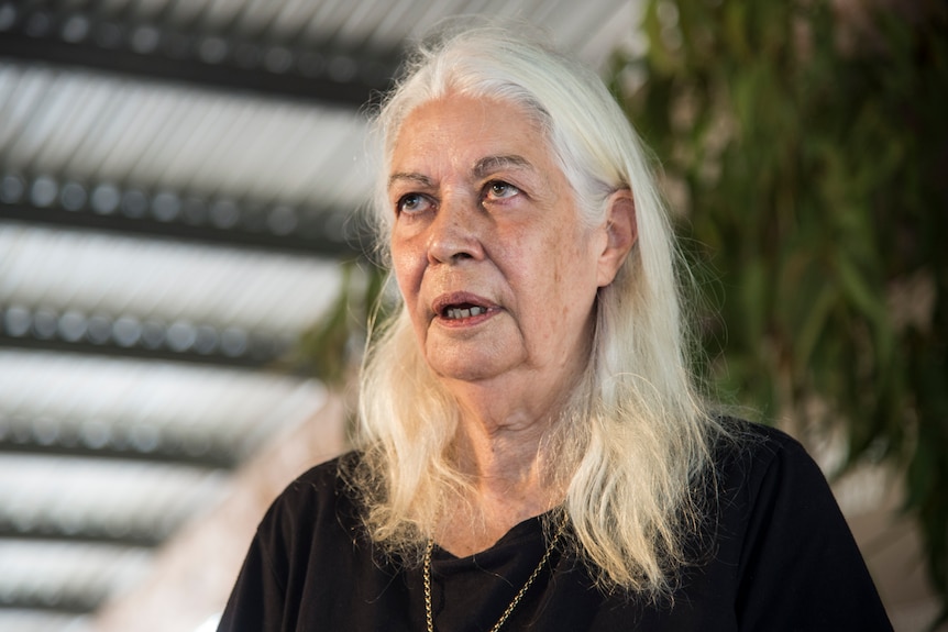 An older Aboriginal woman with long white hair.