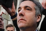 Former Trump lawyer Michael Cohen walks out of a US federal court in a throng of reporters