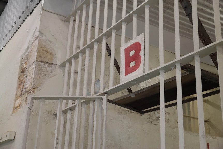 An shot of a sign with the letter 'B' above a jail cell door