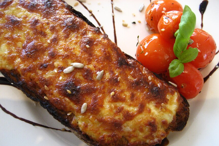 Welsh rarebit on a plate with tomatoes.