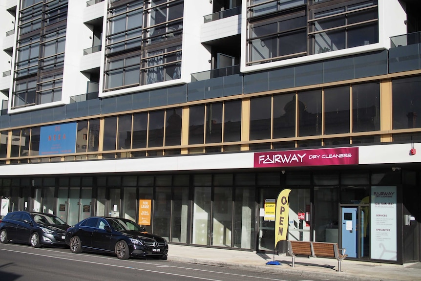 A line of empty shops beneath a new residential development