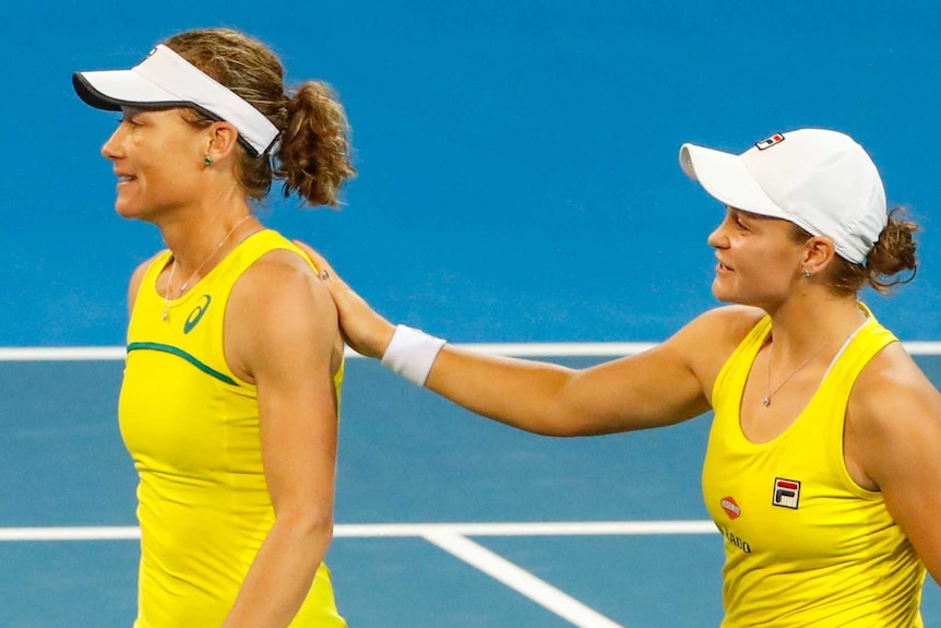 Ash Barty pats Sam Stosur on the back after their doubles win in the Fed Cup semi-final against Belarus.