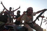 Libyan rebels ride through the town of Maia giving V-for victory sign
